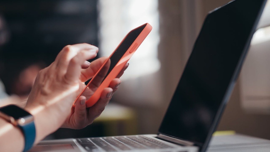 pessoa usando computador e celular para saber: depois da perícia quanto tempo demora para receber o beneficio?