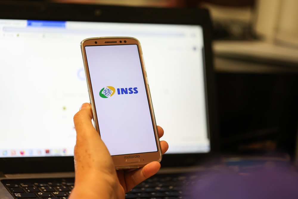 Celular com logo do INSS representa como funciona a isenção do Imposto de Renda para aposentados.