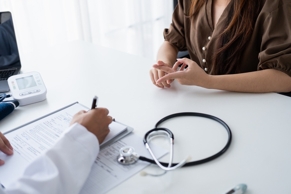 Consulta médica sobre doença profissional e doença do trabalho, com paciente relatando sintomas ao médico.