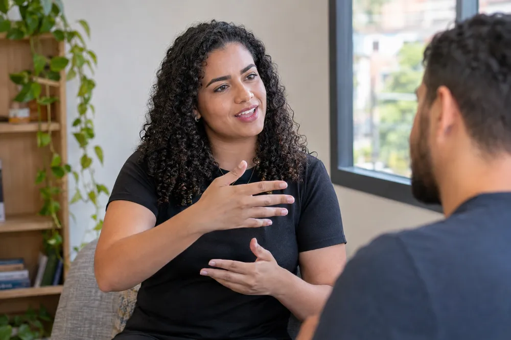 Mulher se comunica por sinais durante conversa, ilustrando a importância de entender como comprovar PCD.